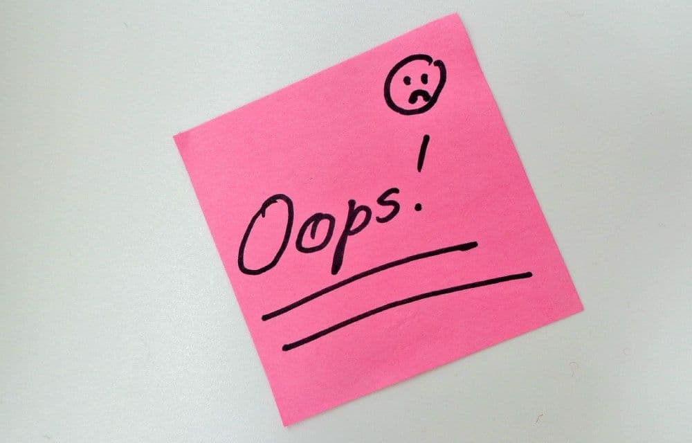 A handwritten sticky note reading "Oops!" with a sad face drawn beside it.